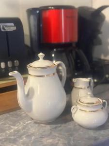 two white teapots are sitting on a counter at Appartement confortable à Gerbépal 55 m² avec sauna in Gerbépal