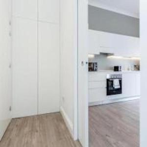 a kitchen with white walls and a wooden floor at Babylon Piccadilly in London