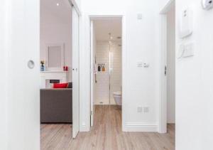 a white bathroom with a toilet and a couch at Babylon Piccadilly in London