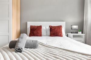 a bedroom with a white bed with red pillows at London Bridge Apartments in London