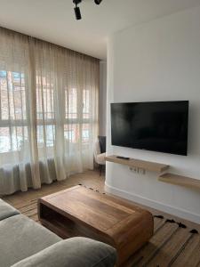 ein Wohnzimmer mit einem Flachbildfernseher an der Wand in der Unterkunft Apartamento Moderno, centro de Ciudad Real in Ciudad Real