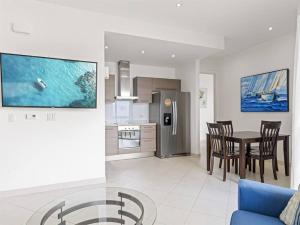 a kitchen and dining room with a table and a blue couch at Luxury Lagoon-View Condo Steps to Beach in Cupecoy