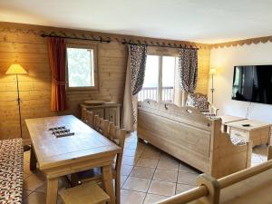 a living room with a table and a tv at Appartement de standing 8 pers avec piscine, spa, parking inclus - FR-1-461-1 in Saint-Martin-de-Belleville