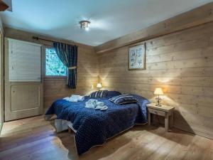 a bedroom with a bed with a blue comforter at Appartement de standing 8 pers avec piscine, spa, parking inclus - FR-1-461-1 in Saint-Martin-de-Belleville +27 photos