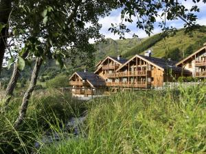 a large wooden building with mountains in the background at Appartement de standing 8 pers avec piscine, spa, parking inclus - FR-1-461-1 in Saint-Martin-de-Belleville