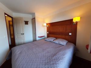 a bedroom with a large bed with a wooden headboard at Charmant T3 à La Plagne-Tarentaise pour 6 personnes, balcon, idéal pour vacances ski - FR-1-353-79 in Montchavin