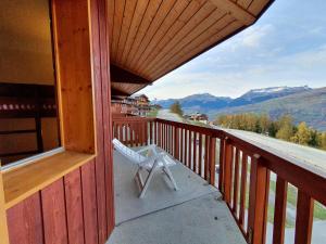 a white chair sitting on the porch of a cabin at Charmant T3 à La Plagne-Tarentaise pour 6 personnes, balcon, idéal pour vacances ski - FR-1-353-79 in Montchavin