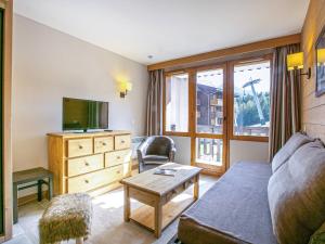 Una sala de estar con un sofá y un televisor. en Appartement cosy 2 pièces, 5 pers, balcon, La Plagne - FR-1-353-81, en Montchavin