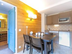 cocina con pared de madera, mesa y sillas en Appartement cosy 2 pièces, 5 pers, balcon, La Plagne - FR-1-353-81, en Montchavin