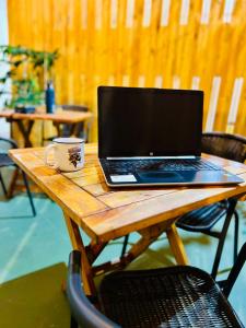 a laptop computer sitting on a wooden table with a coffee cup at Casa Cavancha in Iquique