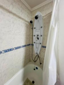 a white bath tub with a shower in a bathroom at Casa Cavancha in Iquique +12 photos