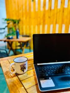 a laptop computer sitting on a wooden table with a coffee cup at Casa Cavancha in Iquique
