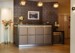 a salon with a waiting room with flowers on the wall at Grand Hôtel Du Nord in Vesoul +46 photos