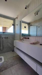 a bathroom with a sink and a shower and a toilet at Hermosa Chacra de Diseño, Pueblo Edén in El Eden