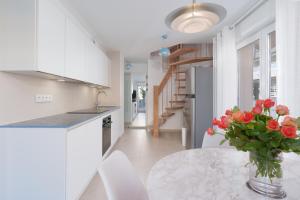 a kitchen with a table with a vase of flowers on it at Les VOILES DE GOLFE in Golfe-Juan