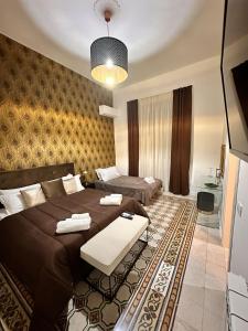 a bedroom with two beds and a table in it at Il Sipario Luxury Apartments in Palermo