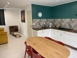 a kitchen with a wooden table and a dining room at Joli studio au calme in Bruay-la-Buissiere
