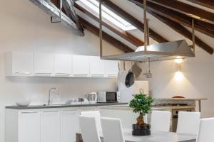 a kitchen with white cabinets and a silver hood at Attic floor venice apartment in Mestre +24 photos