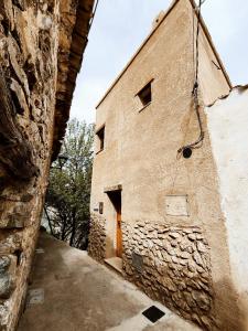 a stone building with a door on the side of it at Cara Norte , Casa Rural-Castillo de Villamalefa in Castillo de Villamalefa