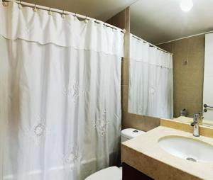 ein Badezimmer mit einem weißen Duschvorhang und einem Waschbecken in der Unterkunft Depto con la mejor vista a la ciudad de Concepción in Concepción + 14 Fotos