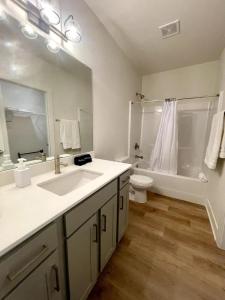 a bathroom with a sink and a toilet and a tub at Papillion The White Pine Modern Spacious with Garage in Papillion +14 photos