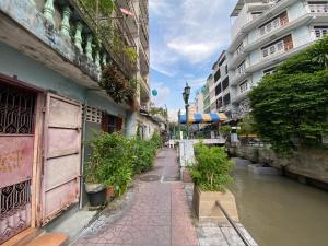 曼谷Bangkok Neighborhood Hostel的建筑物旁边有运河的城市街道