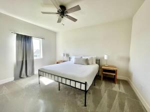 a white bedroom with a bed and a ceiling fan at Papillion The White Pine Modern Spacious with Garage in Papillion