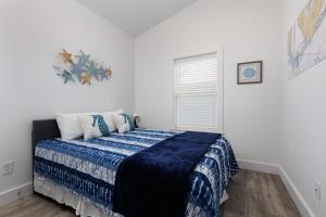 a bedroom with a bed with a blue blanket at The Blue Wahoo in Dauphin Island