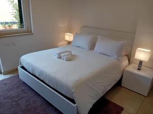 a bedroom with a white bed with two lamps at Appartamento indipendente a Roma Massimina in La Massimina-Casal Lumbroso