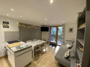 une cuisine et un salon avec une table et un canapé dans l'établissement Appartement cosy 3 pièces, avec balcon et piscine, proche des pistes et commodités à La Plagne Tarentaise - FR-1-353-118, à La Plagne Tarentaise