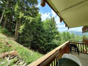 - un balcon d'une maison avec vue sur les bois dans l'établissement Appartement cosy 3 pièces, avec balcon et piscine, proche des pistes et commodités à La Plagne Tarentaise - FR-1-353-118, à La Plagne Tarentaise