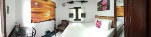 a bedroom with a bed and a painting on the wall at BRICK VILLA in Ahangama