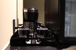 a coffee maker with two coffee cups on a counter at Barceló Mexico Reforma in Mexico City