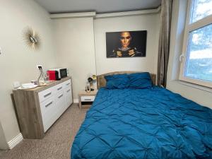 a bedroom with a blue bed and a dresser at Milennium Apart Hotel in Bucharest