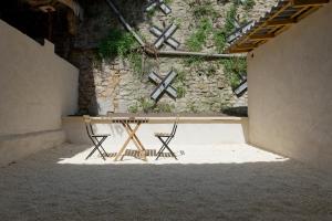a table and two chairs in front of a wall at Appartement de l'UNESCO de Blaye- Spacieux & confort - 2 chambres in Blaye