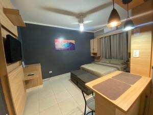 Habitación con 2 camas y escritorio con TV. en kitnet Premium ao lado da praia Canto do Forte, en Praia Grande