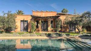 a house with a swimming pool in front of it at The Source Hotel Music & Spa in Marrakesh