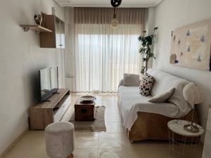 a living room with a couch and a television at Duplex Torre la Sal Magic World La Tormesilla in La Estación