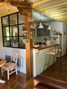 eine Küche mit einer Theke und Stühlen in einem Zimmer in der Unterkunft Chalet de charme in Montfort-sur-Boulzane