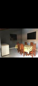 - une salle à manger avec une table, des chaises, une table et des chaises dans l'établissement Casa Oliveira, à Olímpia