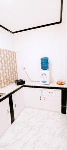 a white kitchen with a white counter top at Getrudis Guesthouse in Labuan Bajo +22 photos