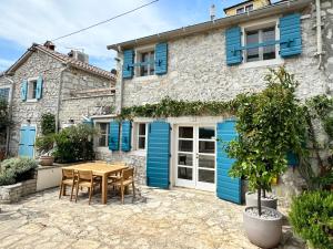 a house with blue doors and a table and chairs at Stone House Orsera in Vrsar +19 photos