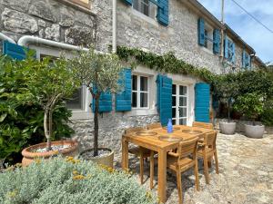 a wooden table and chairs in front of a building at Stone House Orsera in Vrsar