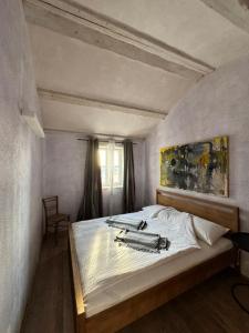 a bedroom with a white bed with a painting on the wall at Stone House Orsera in Vrsar