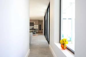 a hallway with white walls and a vase of yellow flowers at Villa Luna 4 Bedroom with Private Pool Oceanfront in Providenciales
