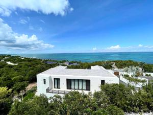 a white house with the ocean in the background at Villa Luna 4 Bedroom with Private Pool Oceanfront in Providenciales +36 photos