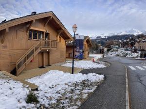 une maison dans une rue avec de la neige au sol dans l'établissement Appartement 3 pièces cosy avec piscine et parking à La Plagne - FR-1-353-123, à La Plagne Tarentaise