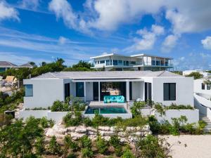a house on the beach with a swimming pool at Villa Pluto 4 Bedroom with Private Pool Oceanfront in Providenciales