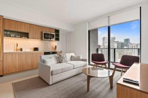a living room with a couch and a table and chairs at Bayside Breeze - Downtown Luxury Tower in Miami