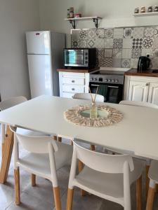 a kitchen with a white table and chairs at Casa Cielo in San Antonio de Areco +8 photos